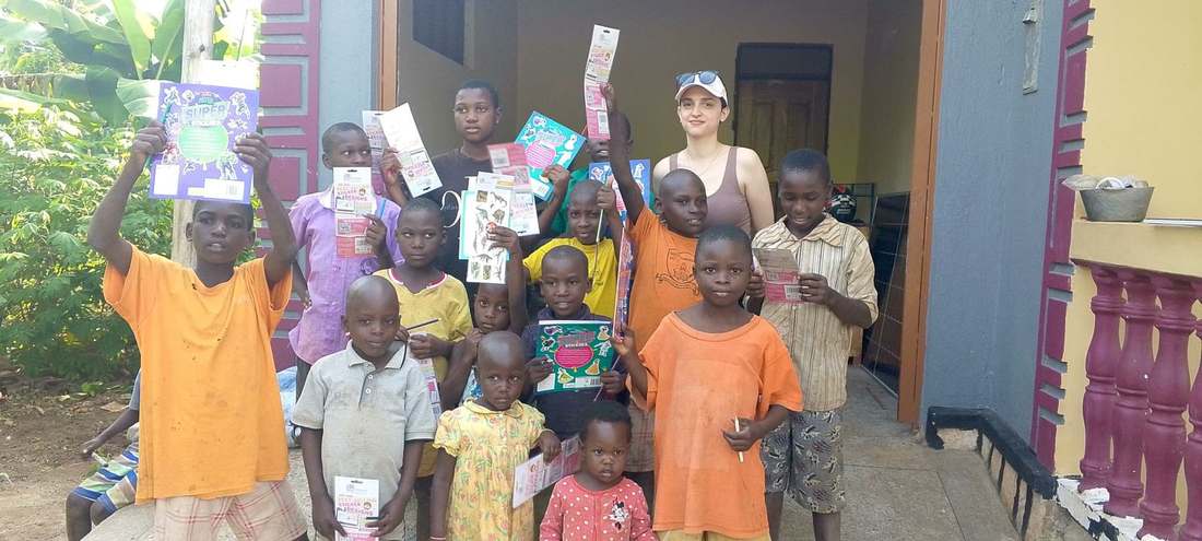 Children showing sticker books and gifts during a community visit